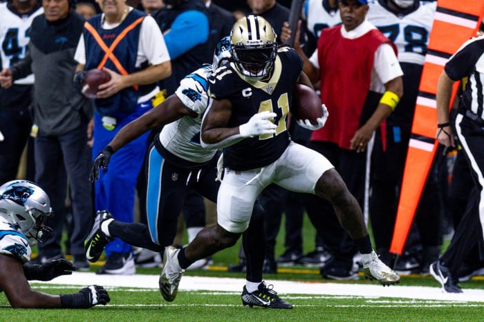 Jan 8, 2023; New Orleans Saints running back Alvin Kamara (41) runs past Carolina Panthers defensive tackle Derrick Brown (95) and safety Xavier Woods (25). Mandatory Credit: Stephen Lew-USA TODAY Sports